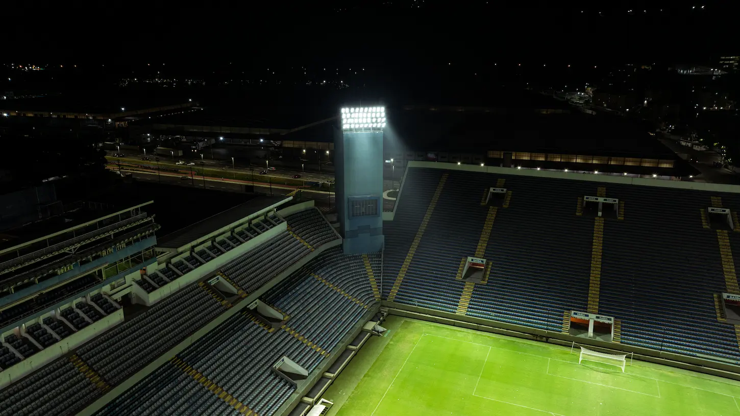 Foto de um projetor iluminando um campo de futebol