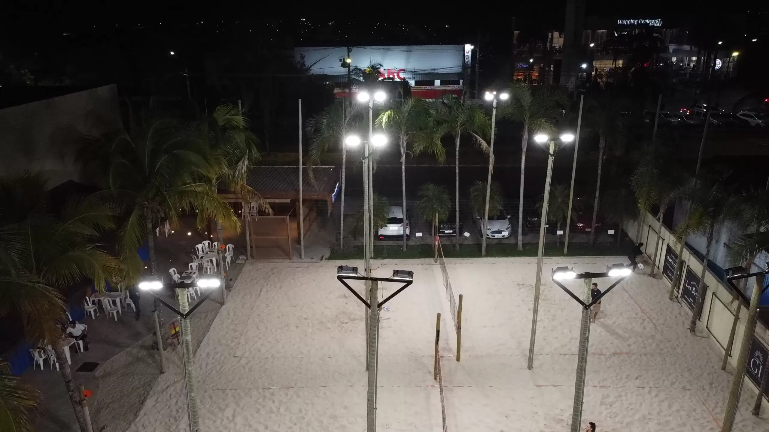 Foto de uma quadra de beach tennis iluminada.