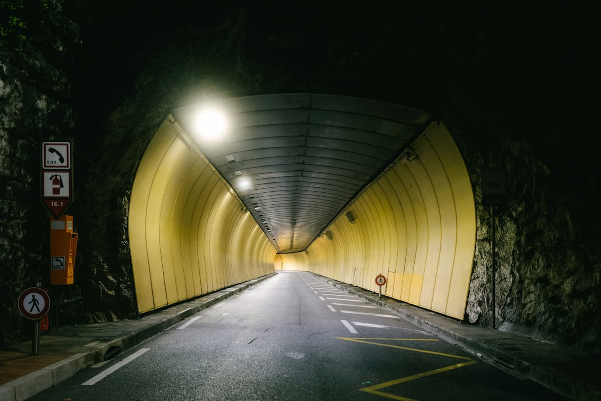 Túnel urbano com iluminação em período noturno.