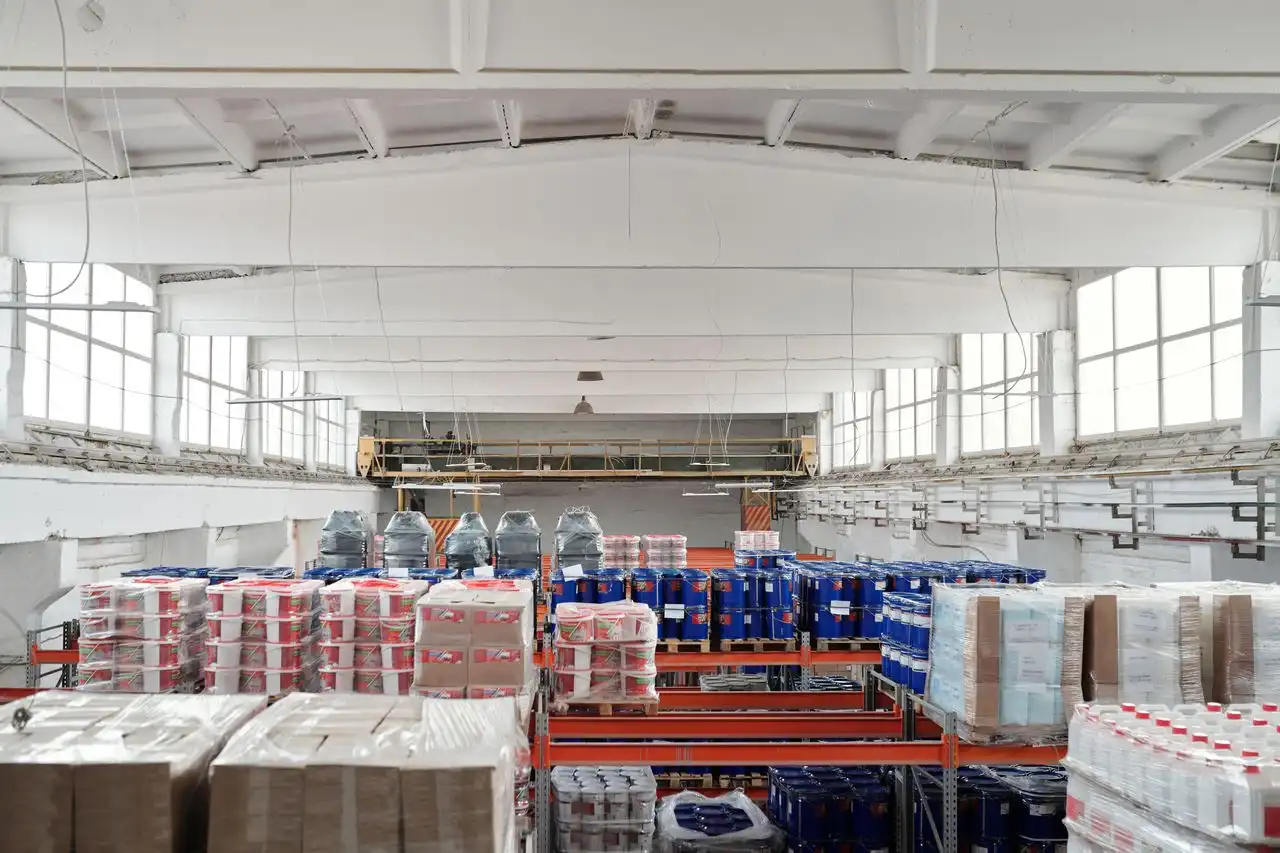 Imagem de um galpão com diversas mercadorias armazenadas em pallets e prateleiras.
