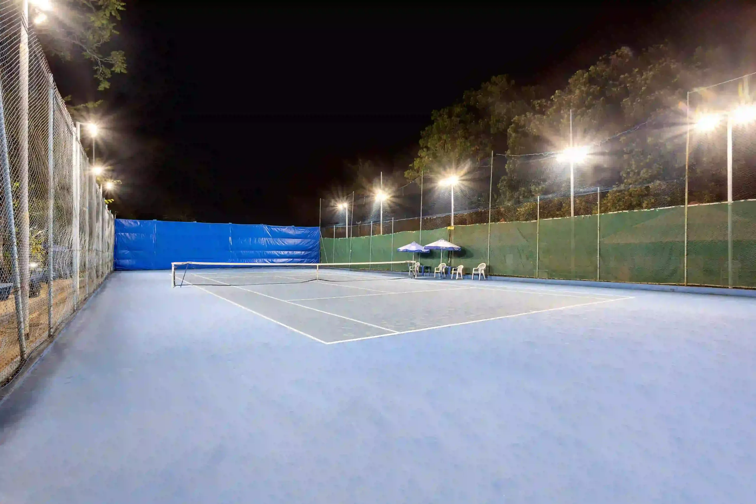 Imagem de uma quadra esportiva à noite, bem iluminada.