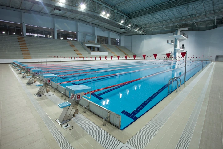A imagem mostra a área interna da piscina de um clube, com iluminação bem distribuída, proporcionando um ambiente claro, seguro e agradável.