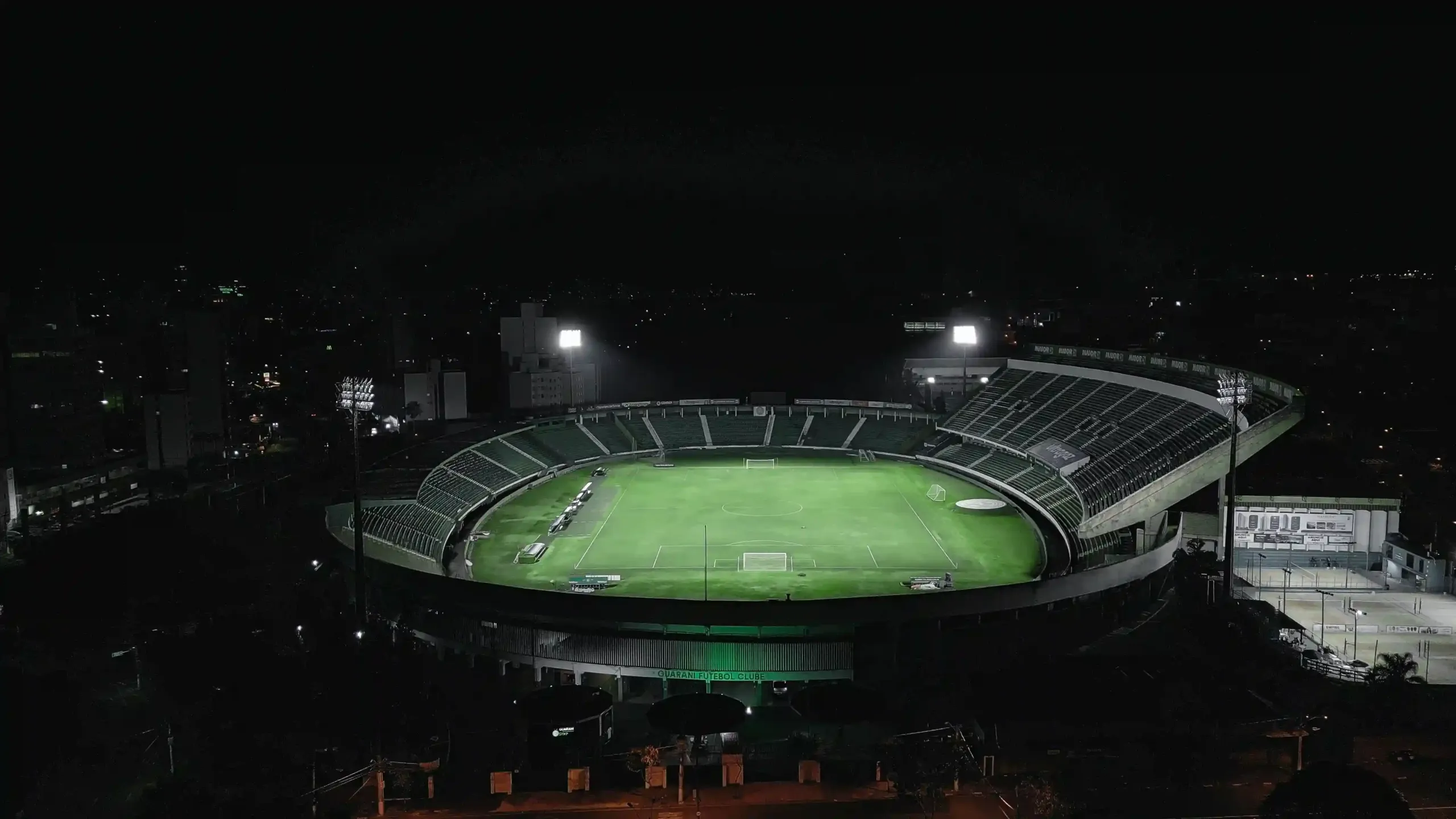 tecnologia-iluminacao-esportiva-em-arenas Imagem de uma arena esportiva bem iluminada durante a noite, com refletores acesos destacando o campo e as arquibancadas.