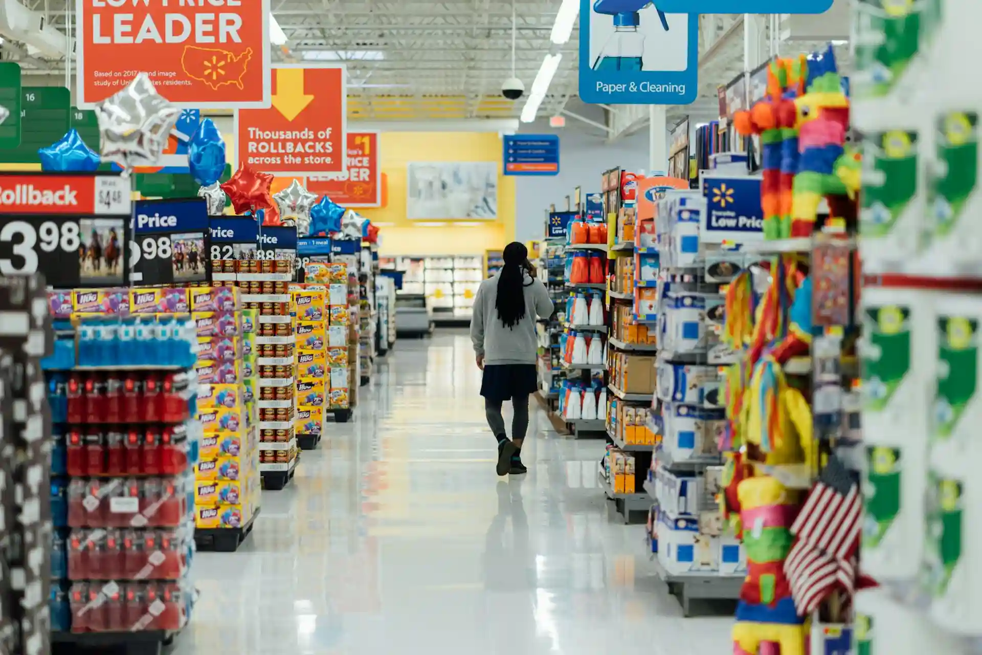 imagem mostra um homem caminhando em um coredor de supermercado