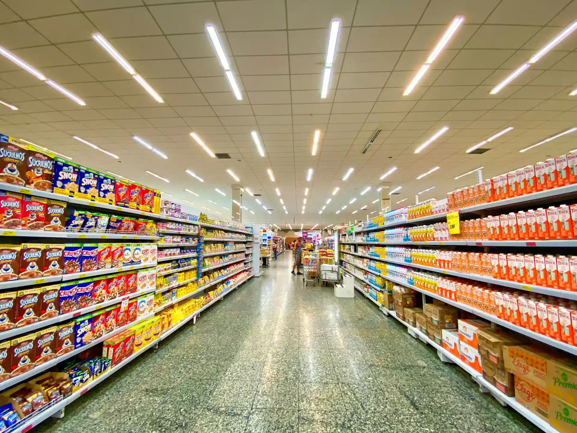 Imagem de um corredor de supermercado bem iluminado.