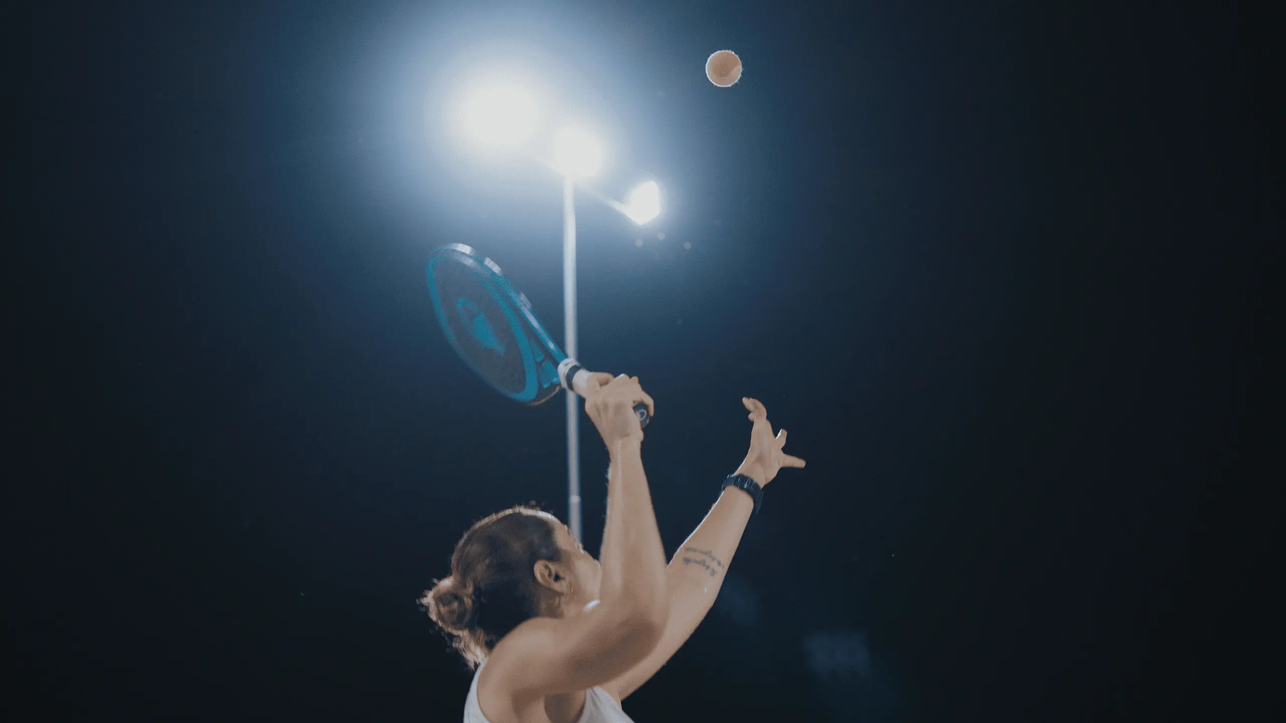 Imagem de uma mulher praticando esporte em uma quadra esportiva.